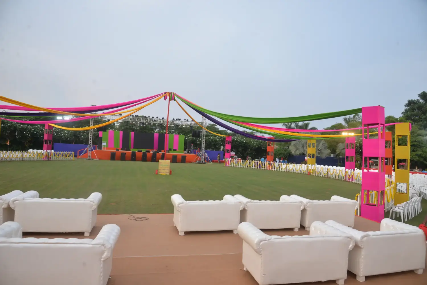 Balloon arch in orange, black, and white colors framing an ITT logo board lit with warm lights